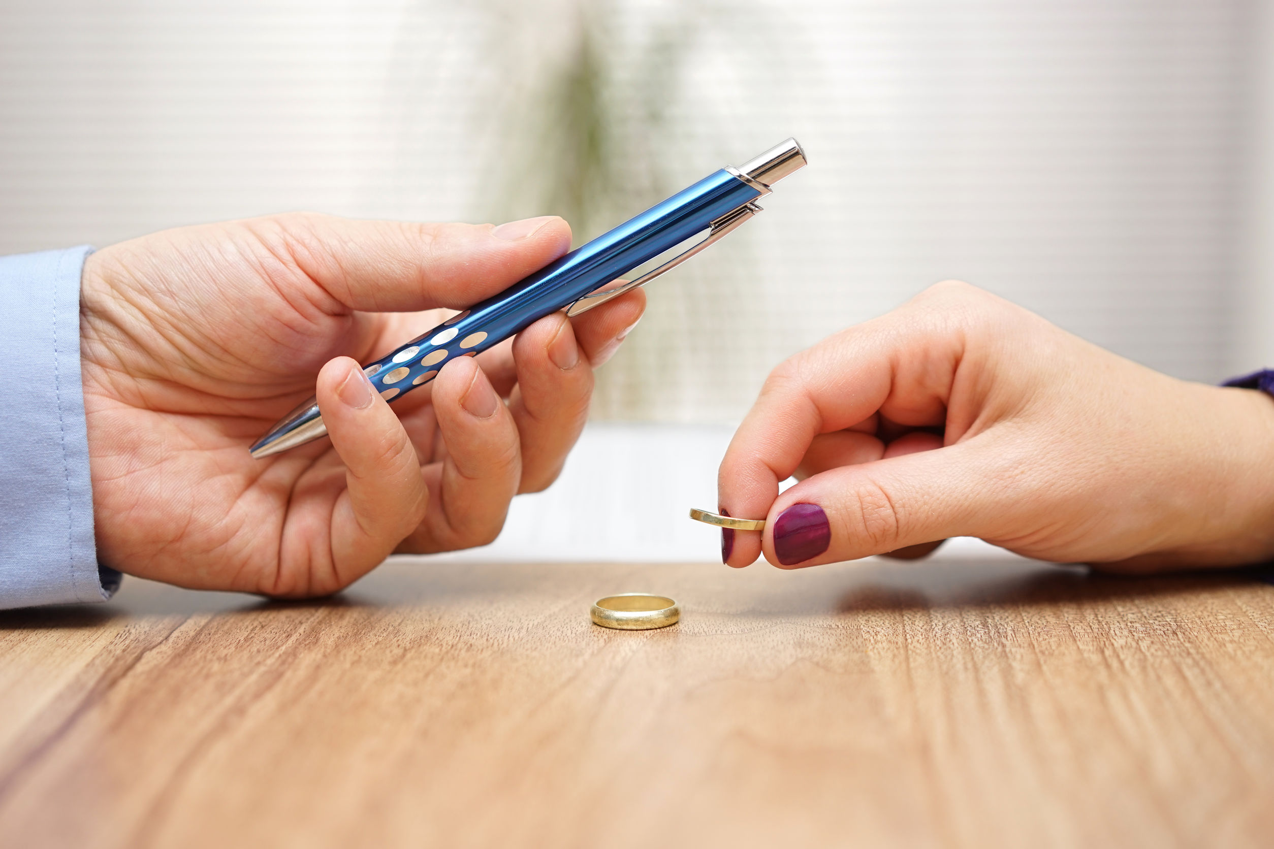 Husband is giving pen to sign divorce papers his former wife aft